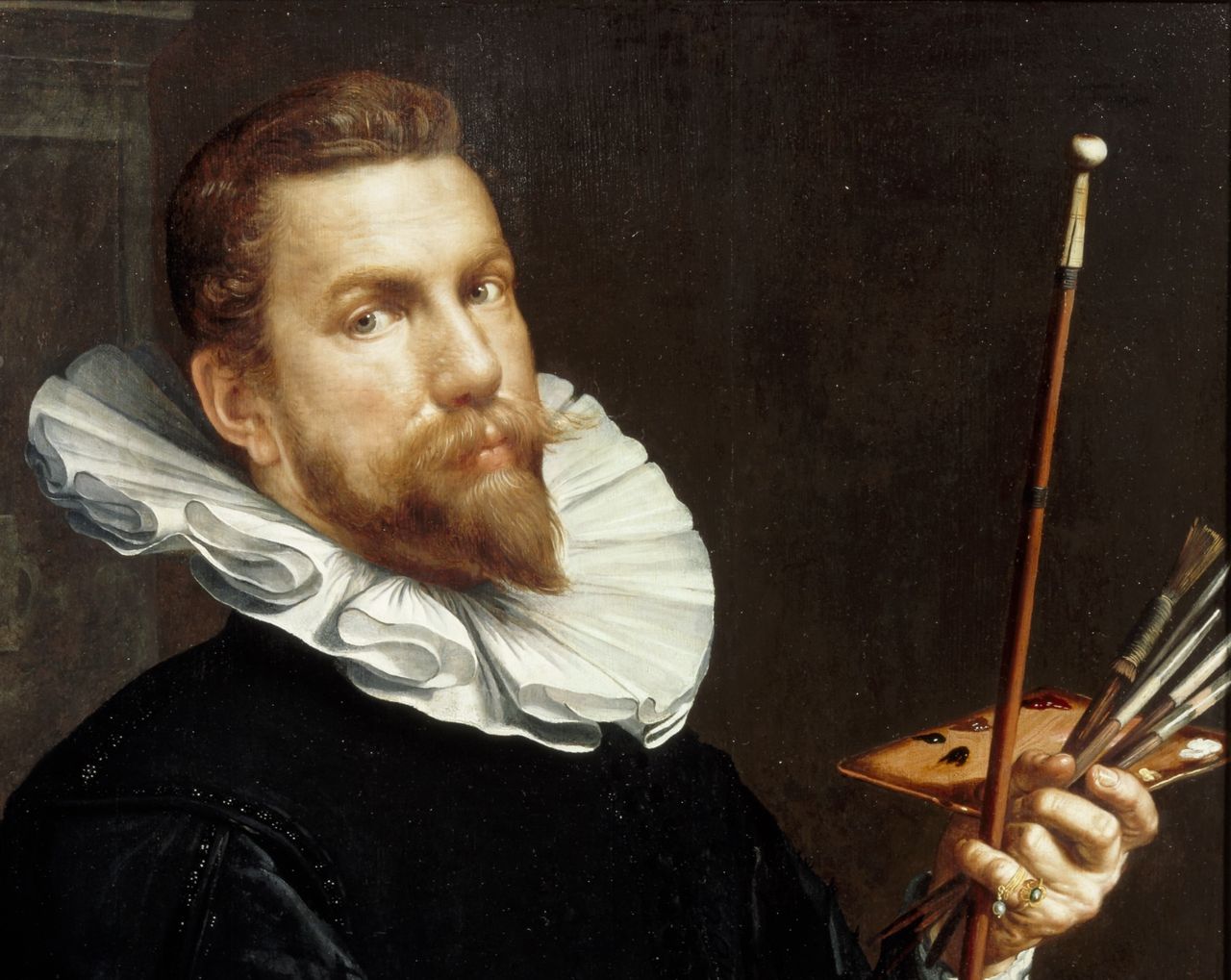 Zeventiende-eeuws zelfportret van Joachim Wtewael, gekleed in het zwart met een witte kraag, en zittend op een stoel bekleed met rode fluwelen stof. In zijn handen houdt hij een palet, penselen en een schilderstok vast. Met op de achtergrond een inscriptie die het jaar 1601 aangeeft en het motto "NON GLORIA SED GRATIA".