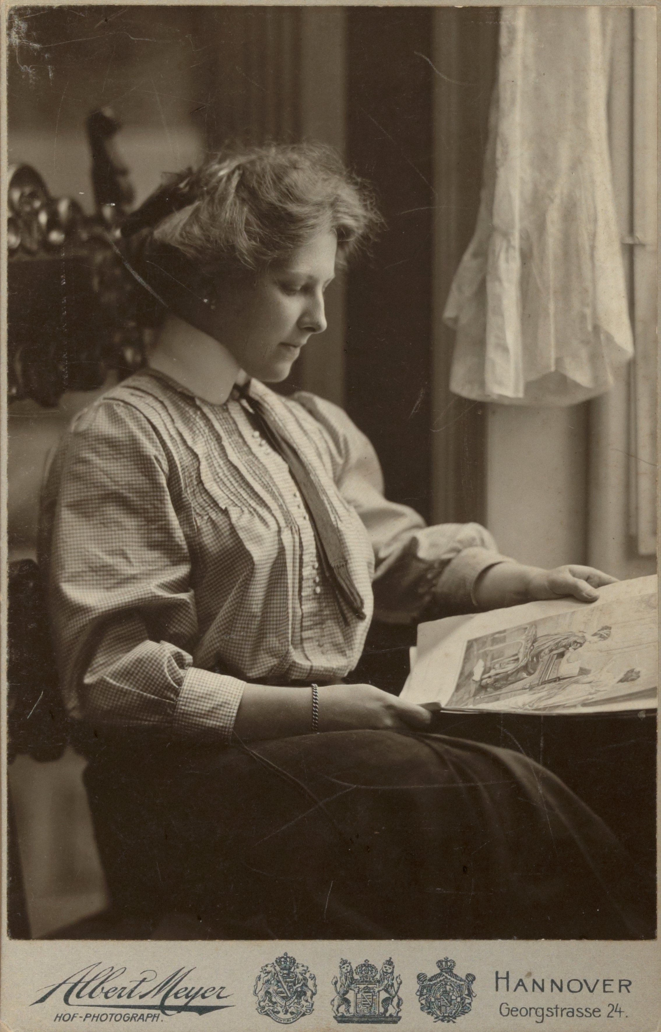 Een jonge Truus Schröder geconcentreerd lezend in een boek, zittend naast een raam, in een historische foto door fotograaf Albert Meyer uit Hannover.
